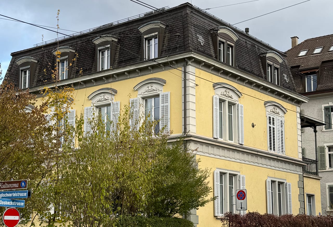 Praxisgebäude an der Klosbachstrasse 51 in Zürich — klassizistisches Wohnhaus mit gelber Fassade und Mansardendach